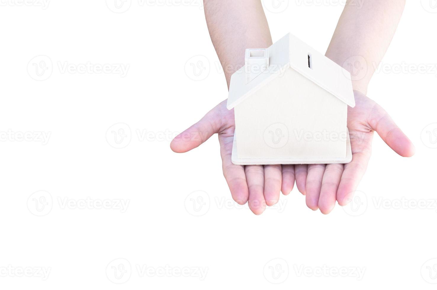 mão segurando uma pequeno de madeira casa isolado em branco fundo. conceito do casa empréstimo e comprando uma casa, seguro. foto