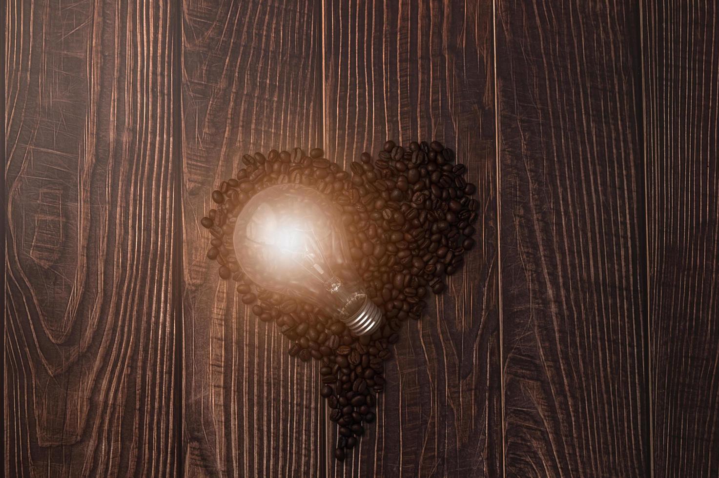 grãos de café em formato de coração, lâmpadas emitem energia foto