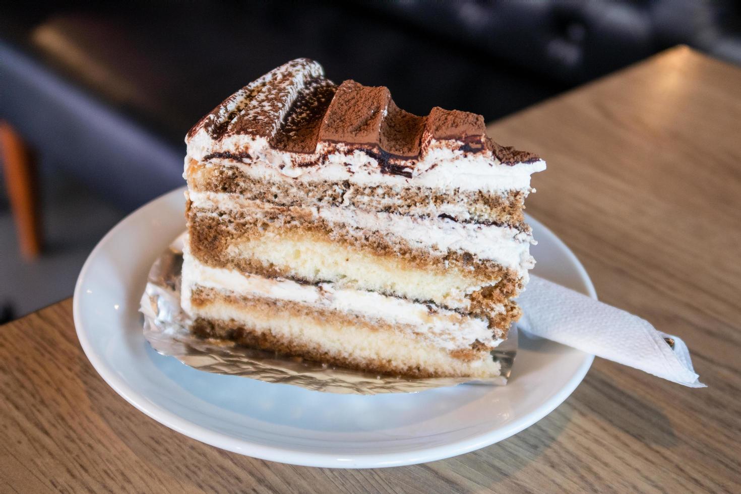 um pedaço de bolo de tiramisu em um prato branco foto