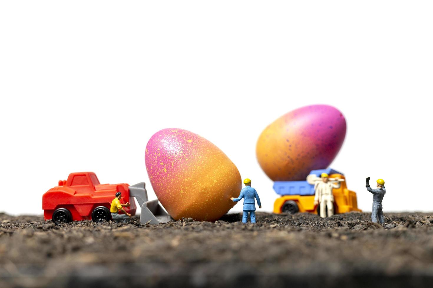 pessoas em miniatura trabalhando em ovos de páscoa para o dia de páscoa com um fundo branco foto