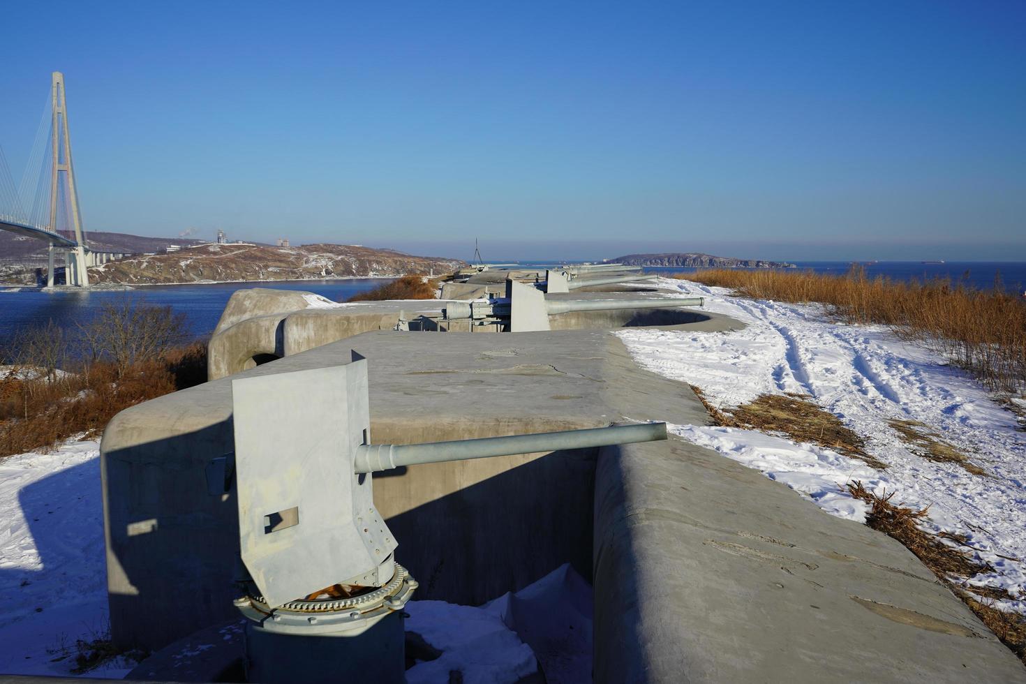 vista panorâmica da bateria voroshilov e da ponte russky contra um céu azul claro em vladivostok, rússia foto