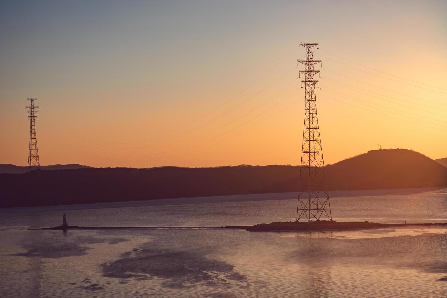 paisagem marítima com pôr do sol sobre o farol de Tokarev e a baía de Amur em Vladivostok, Rússia foto