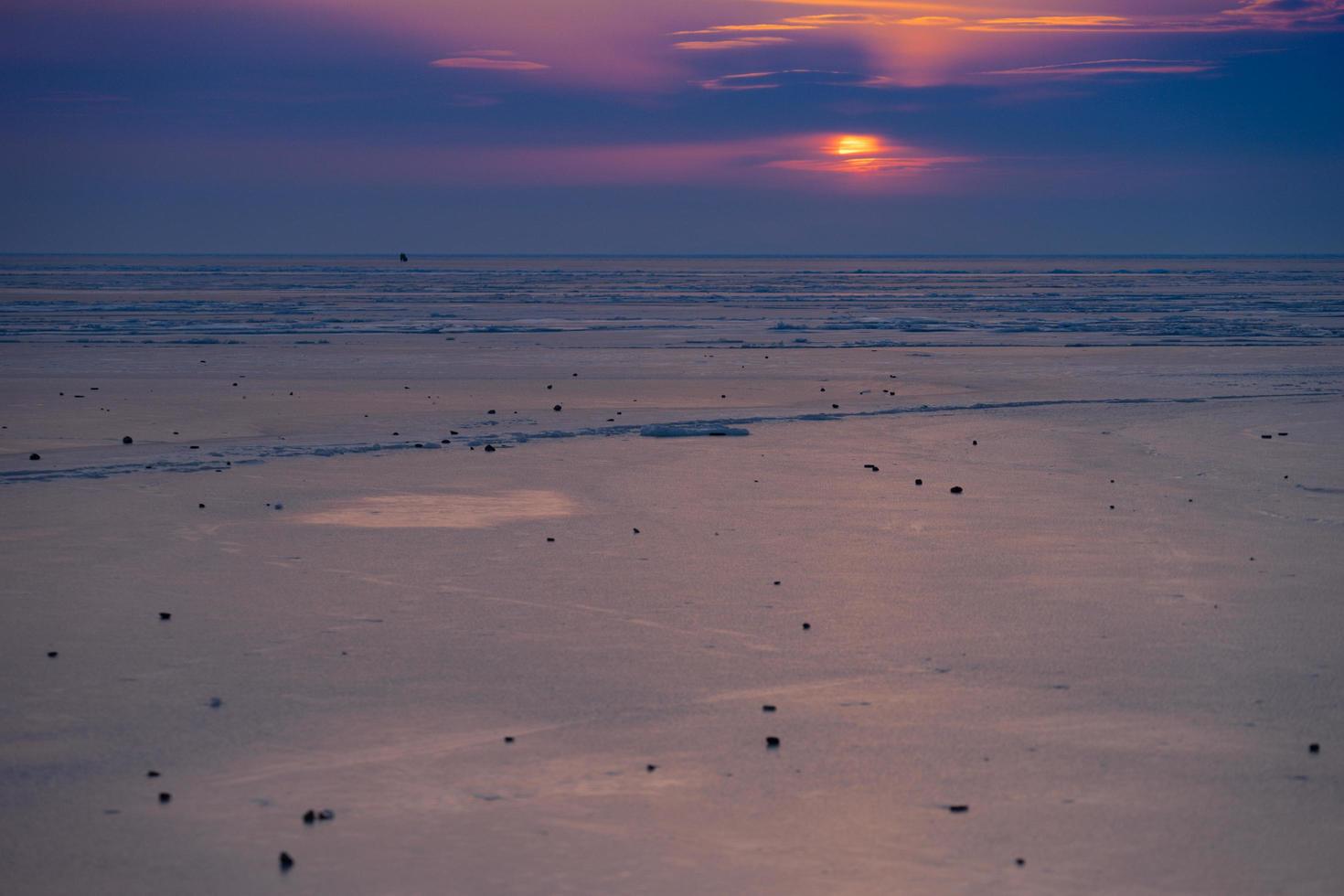 Pôr do sol nublado colorido na praia na baía de Amur em Vladivostok, Rússia foto