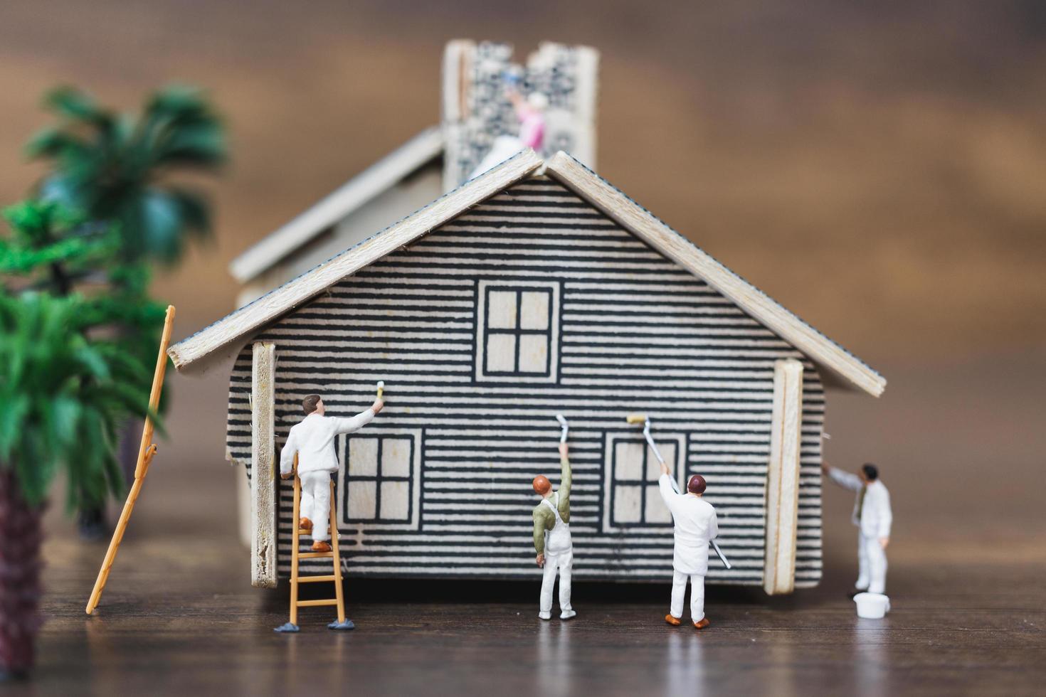 trabalhadores em miniatura pintando uma nova casa, conceito de renovação foto