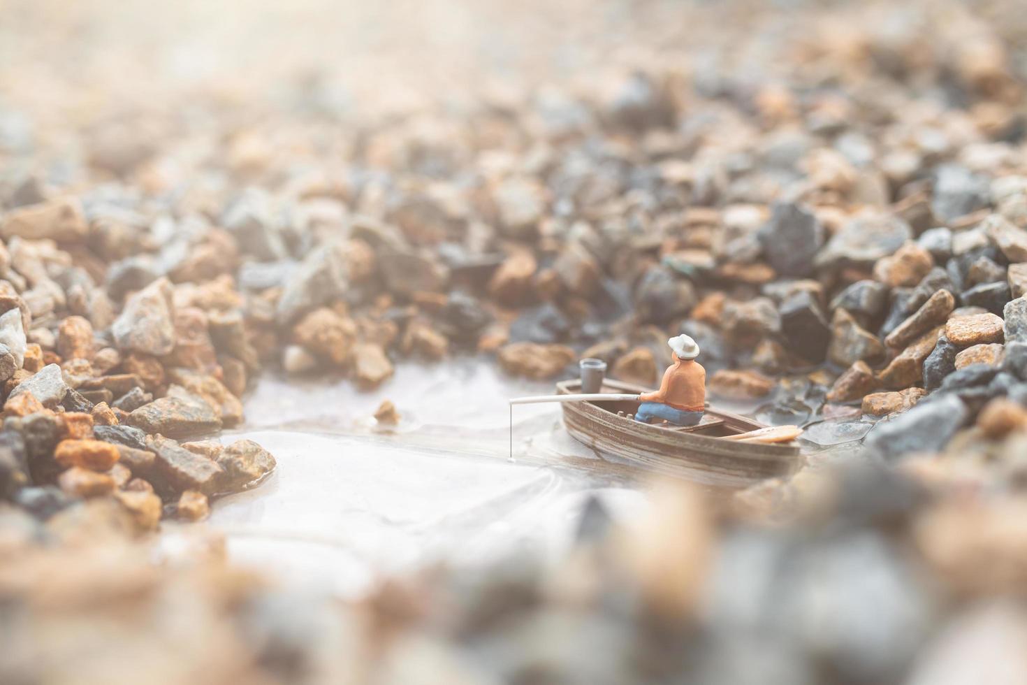 pescador em miniatura pescando em um barco foto