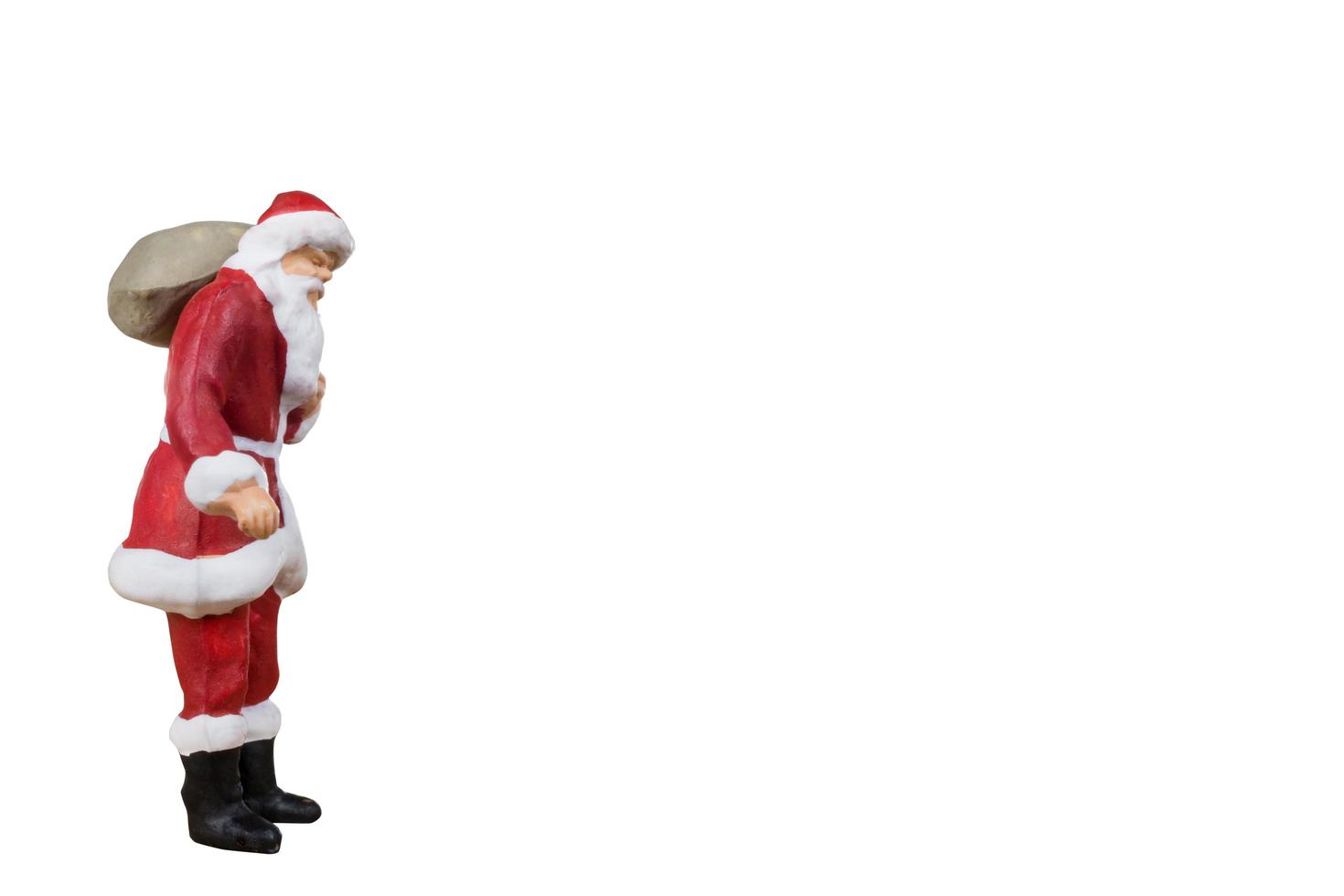 Papai Noel em miniatura carregando uma bolsa isolada em um fundo branco foto