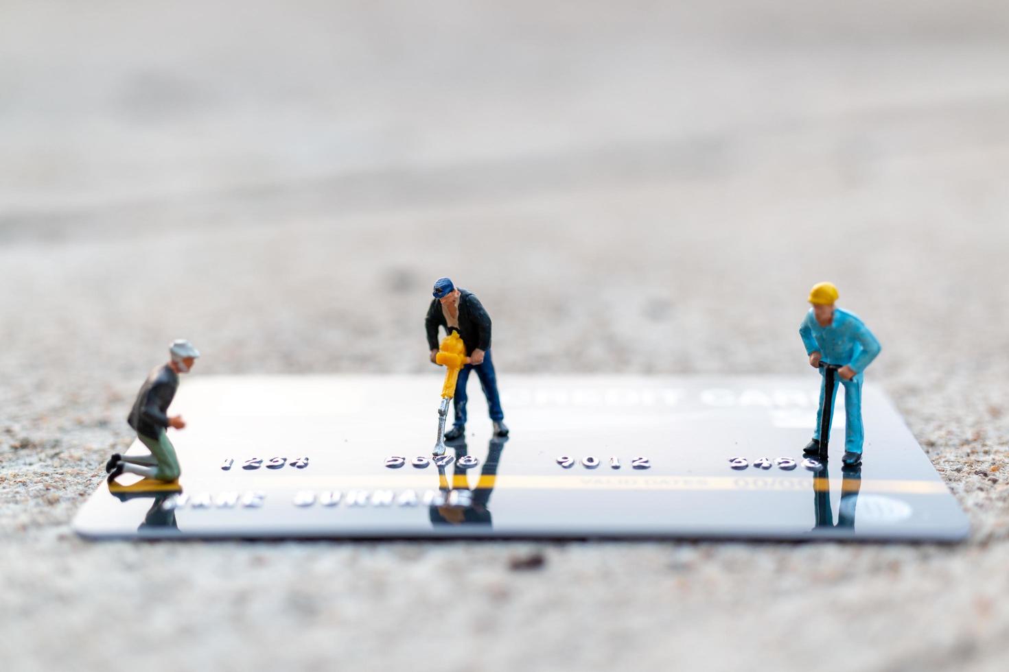 trabalhadores em miniatura trabalhando em um conceito de cartão de crédito, negócios e finanças foto