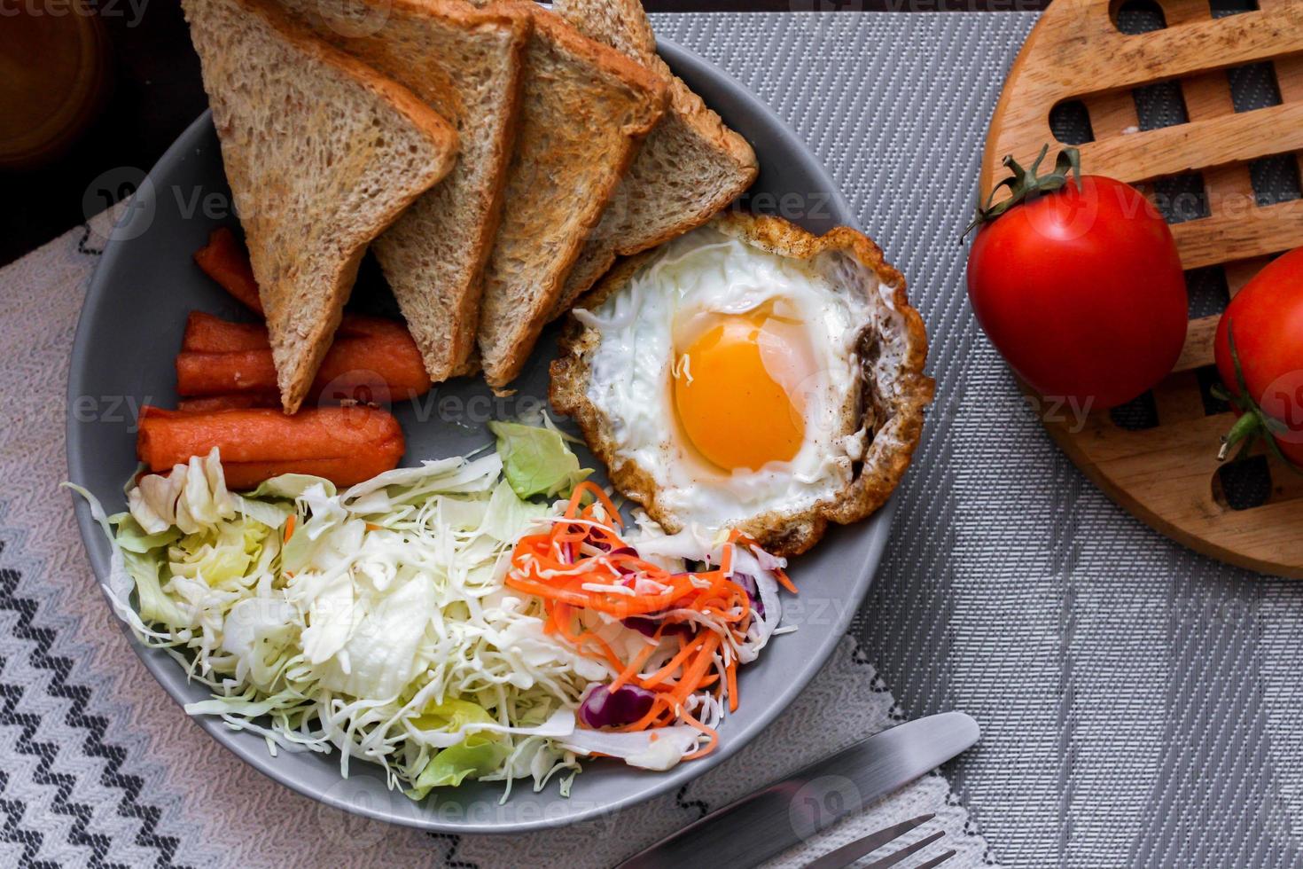 café da manhã, frito ovos, frito salsicha, vegetal salada e torrada em uma Castanho de madeira mesa com café. foto