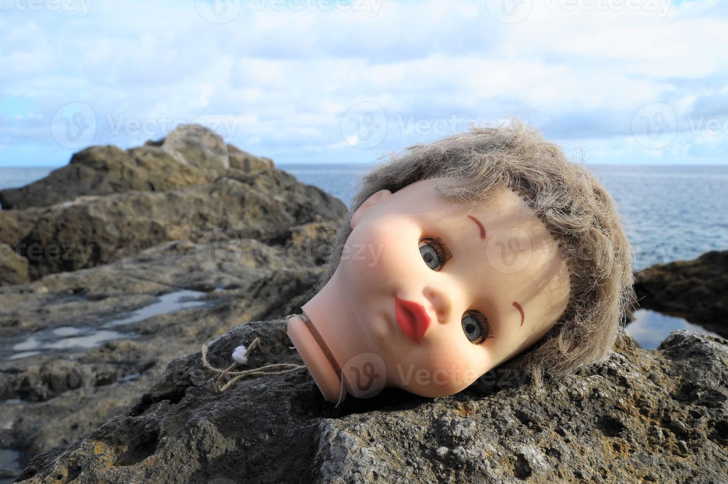 brinquedo boneca deitado em a pedras foto