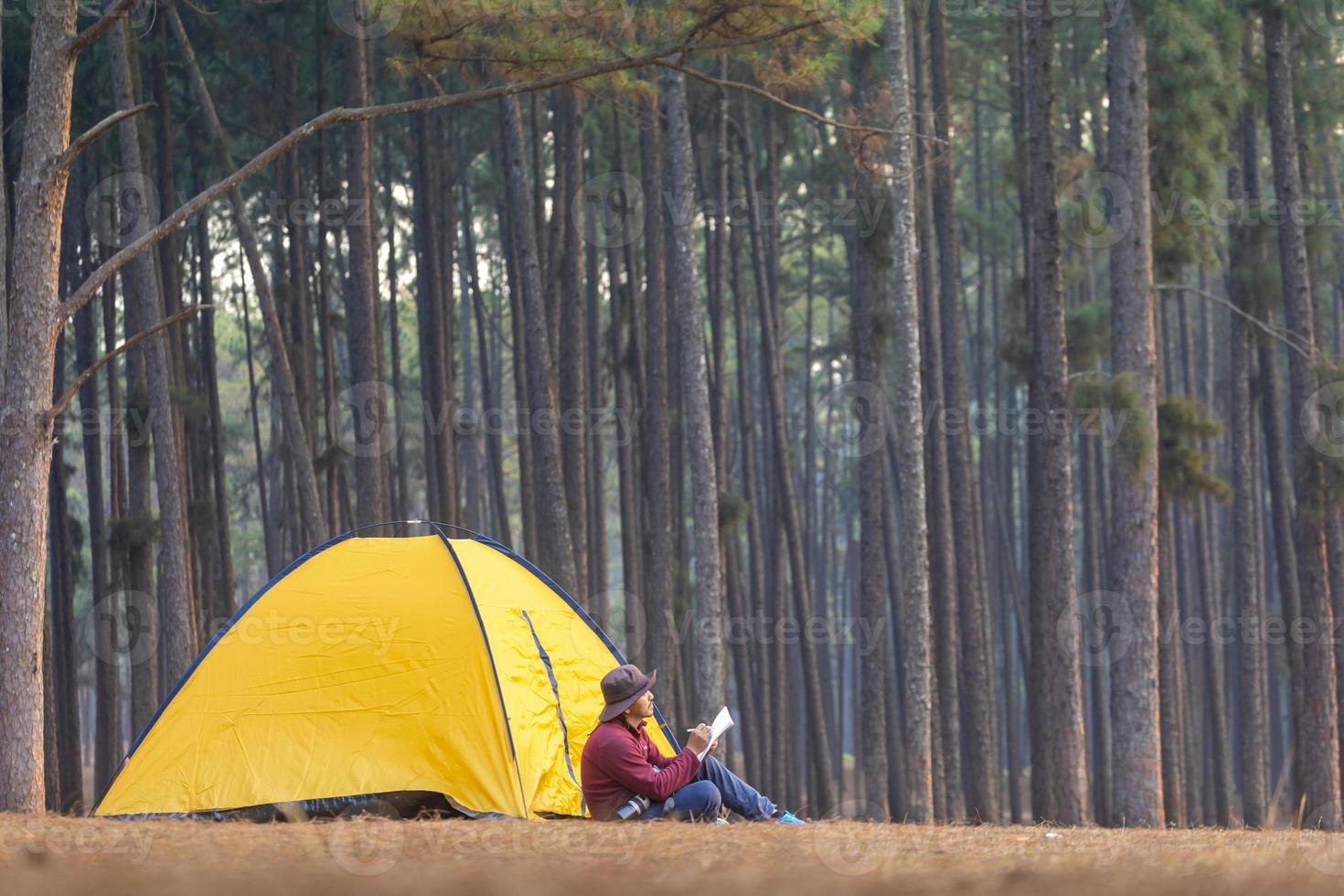 só durante a noite acampamento enquanto sentado ao lado barraca às acampamento dentro a pinho floresta enquanto escrevendo Diário para liberdade, solidão, pacificamente relaxamento cai fora para região selvagem e natureza cura terapia foto