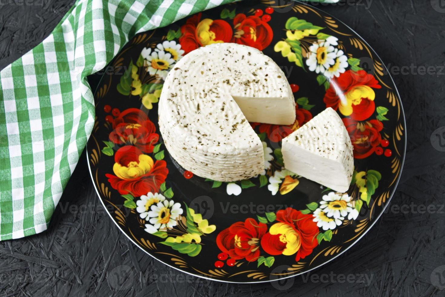 queijo branco em um prato em um fundo preto e guardanapo foto