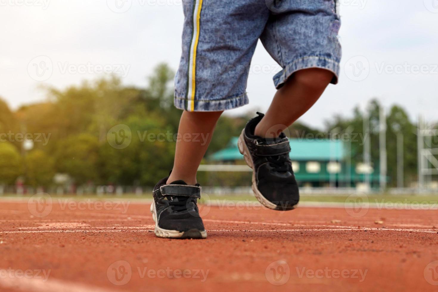 corrida frente em a esteira do a ásia garoto. a conceito do ao ar livre jogar, ao ar livre Atividades, lazer Atividades, exercício. suave e seletivo foco. foto