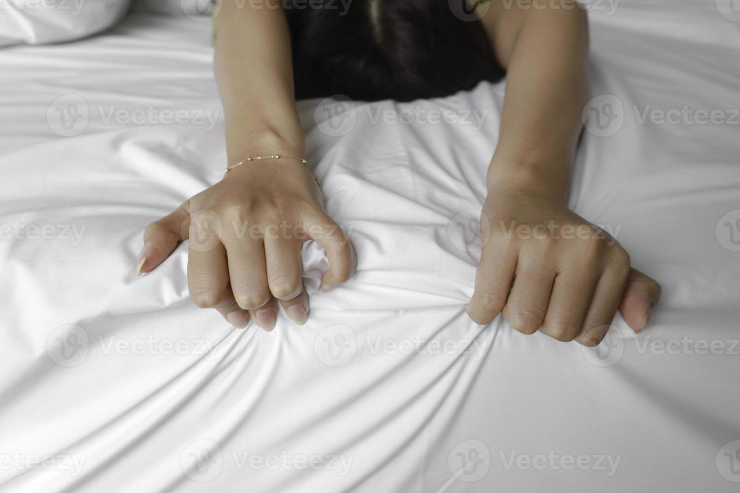 uma foto do uma homem e mulher mãos tendo sexo em uma cama. faço amar.