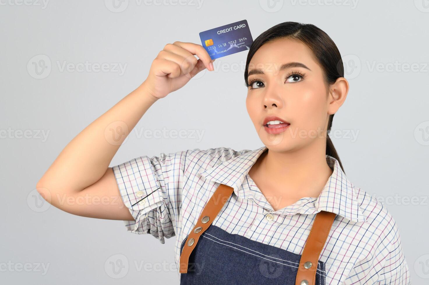 retrato de jovem asiática em uniforme de garçonete pose com cartão de crédito foto