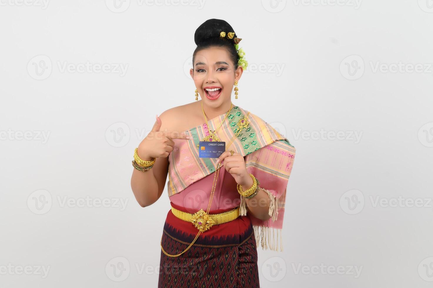 retrato de linda mulher tailandesa em roupas tradicionais posando com cartão de crédito foto