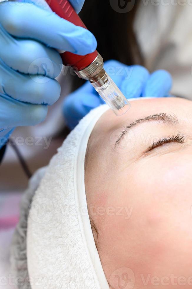 a processo do rejuvenescimento e hidratante com a Socorro do a darsonval cosmetologia dispositivo. foto