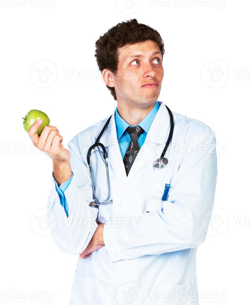 retrato do uma masculino médico segurando verde maçã em branco foto