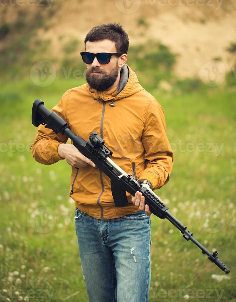 uma homem com a automático rifle foto