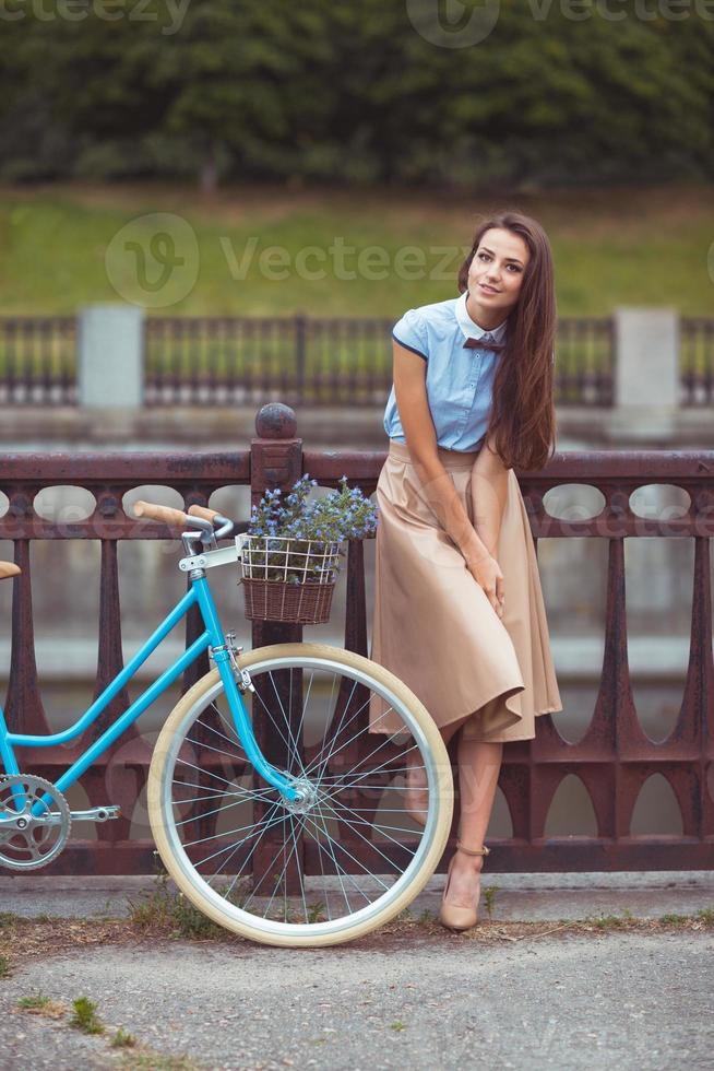 jovem lindo, elegantemente vestido mulher com bicicleta, verão e estilo de vida foto