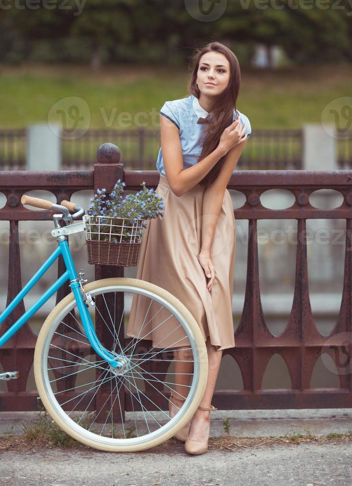 jovem bonita e elegantemente vestida com bicicleta foto