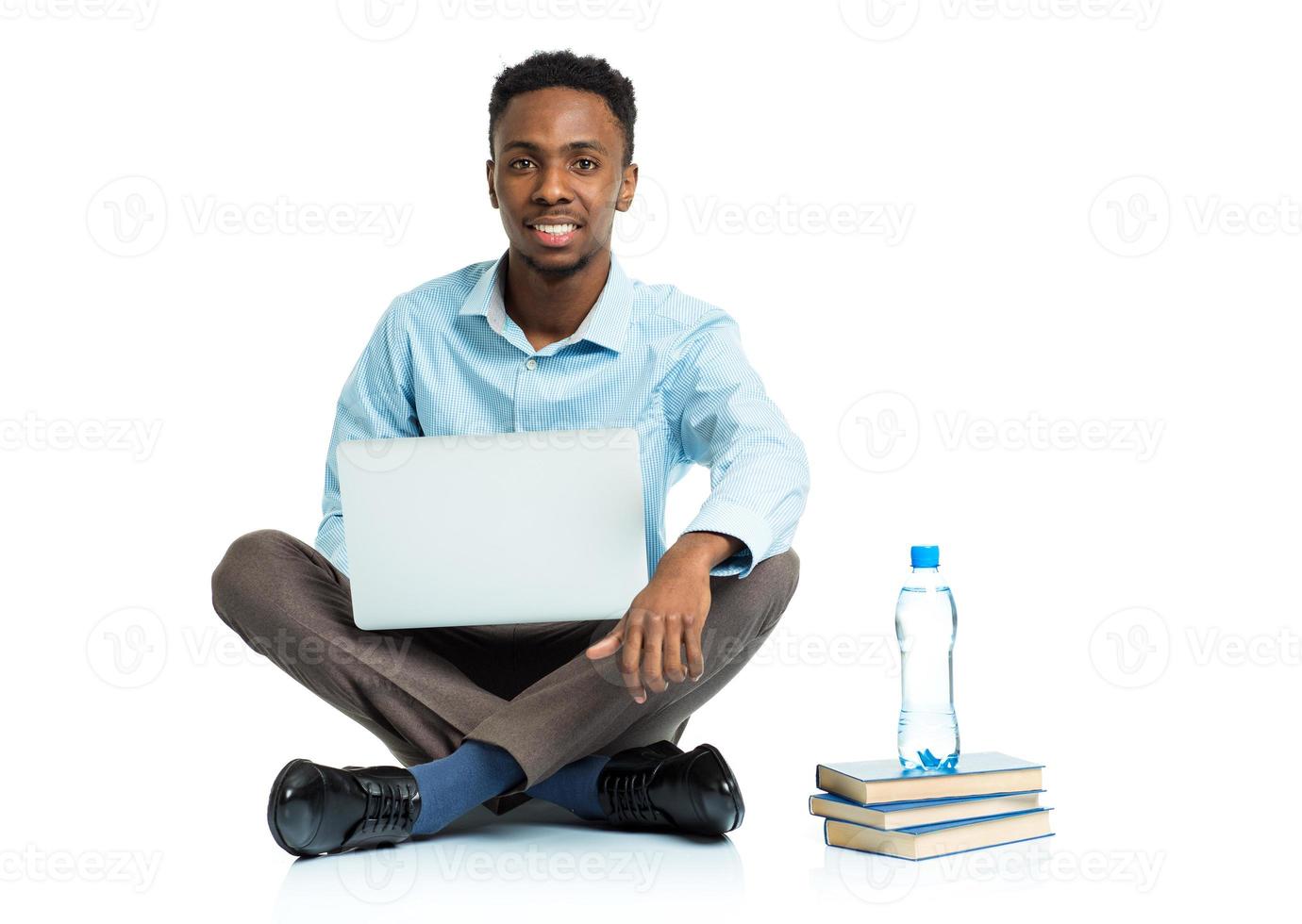 feliz africano americano Faculdade aluna com computador portátil, livros e garrafa do água sentado em branco foto