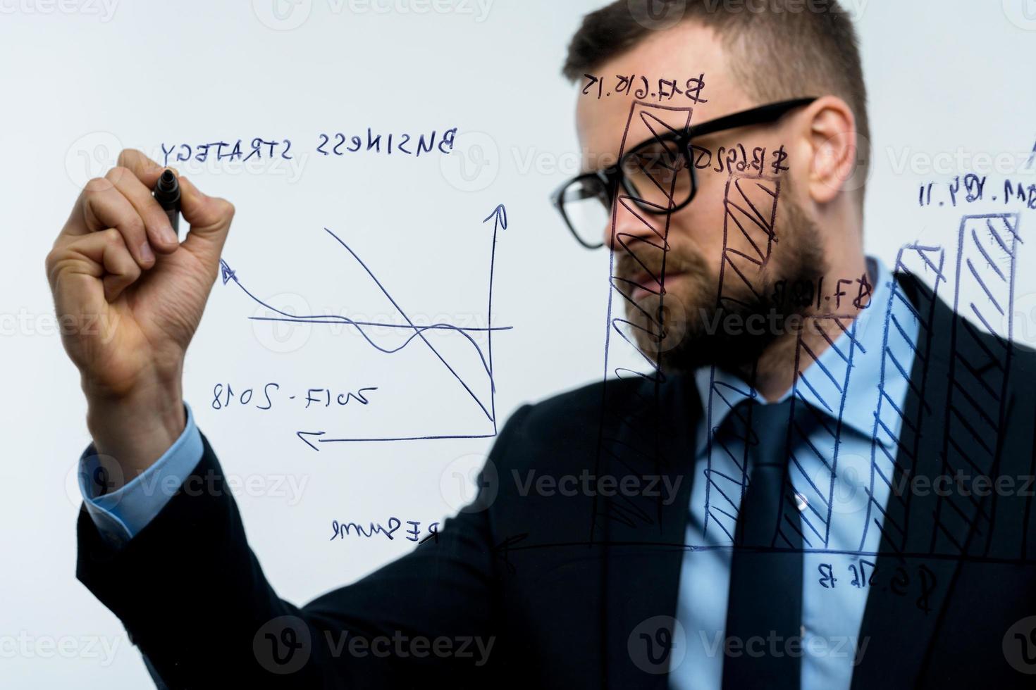 homem desenha vários crescimento gráficos, calculando perspectivas para sucesso dentro uma moderno vidro escritório foto