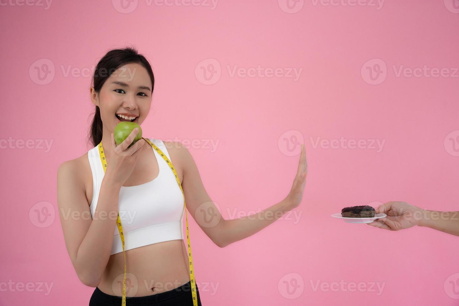 dieta e dieta. beleza fino fêmea corpo confundir rosquinha. mulher dentro exercício roupas atinge peso perda objetivo para saudável vida, louco sobre magreza, fino cintura, nutrição foto