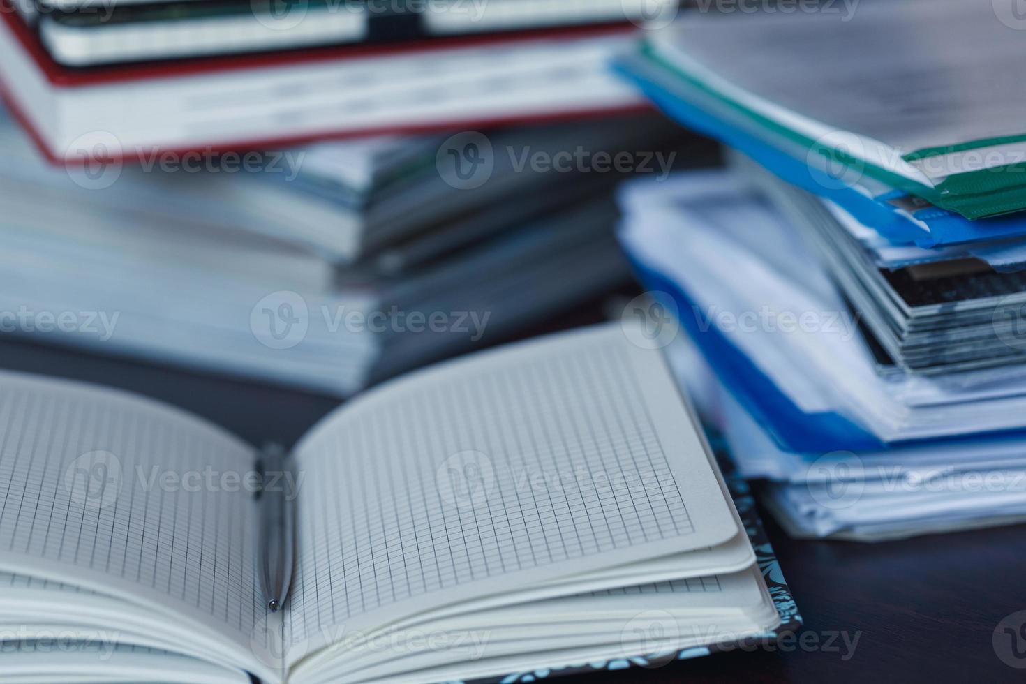 ampla pilha do revista, caderno e livros fechar-se foto