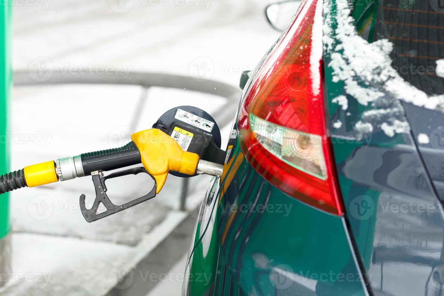 carro reabastecimento em uma gasolina estação dentro inverno foto