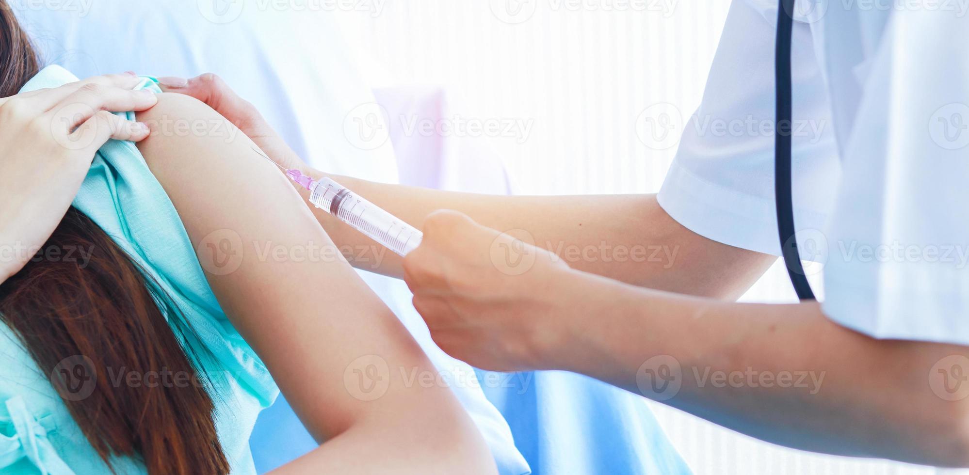médica injetando uma seringa em um paciente foto