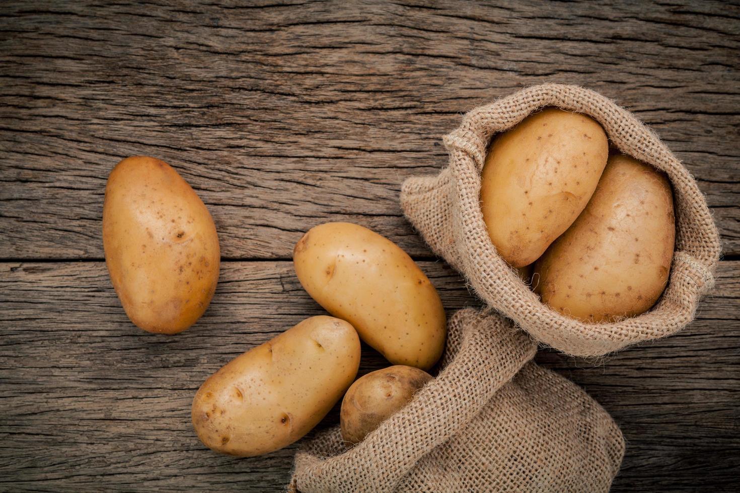 sacos de batatas na madeira foto