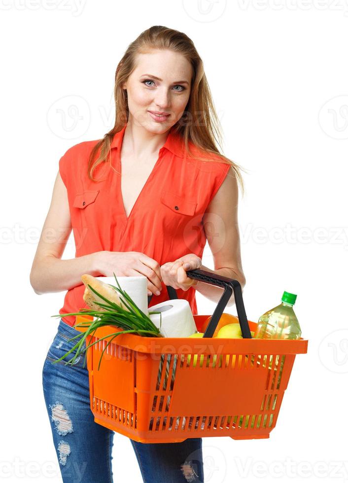 feliz jovem mulher segurando uma cesta cheio do saudável Comida em branco. compras foto