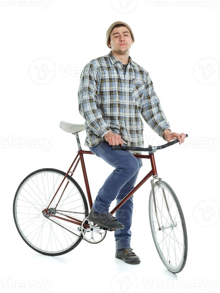 jovem homem fazendo truques em fixo engrenagem bicicleta em uma branco foto