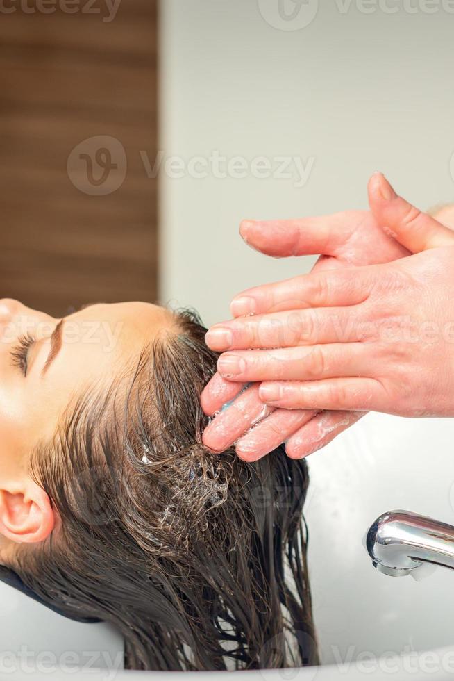 jovem mulher lavando dela cabelo foto