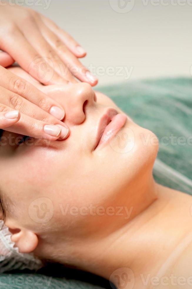 jovem mulher obtendo facial massagem foto