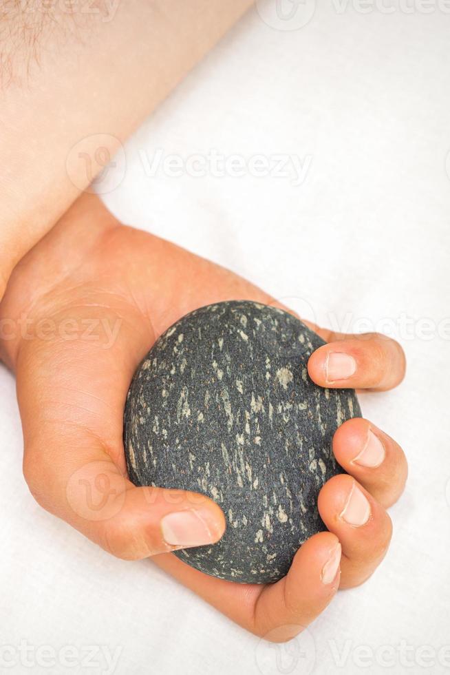 massagista segurando quente massagem pedras foto