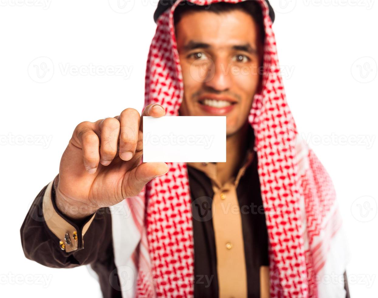jovem sorridente árabe mostrando o negócio cartão dentro mão isolado em branco foto