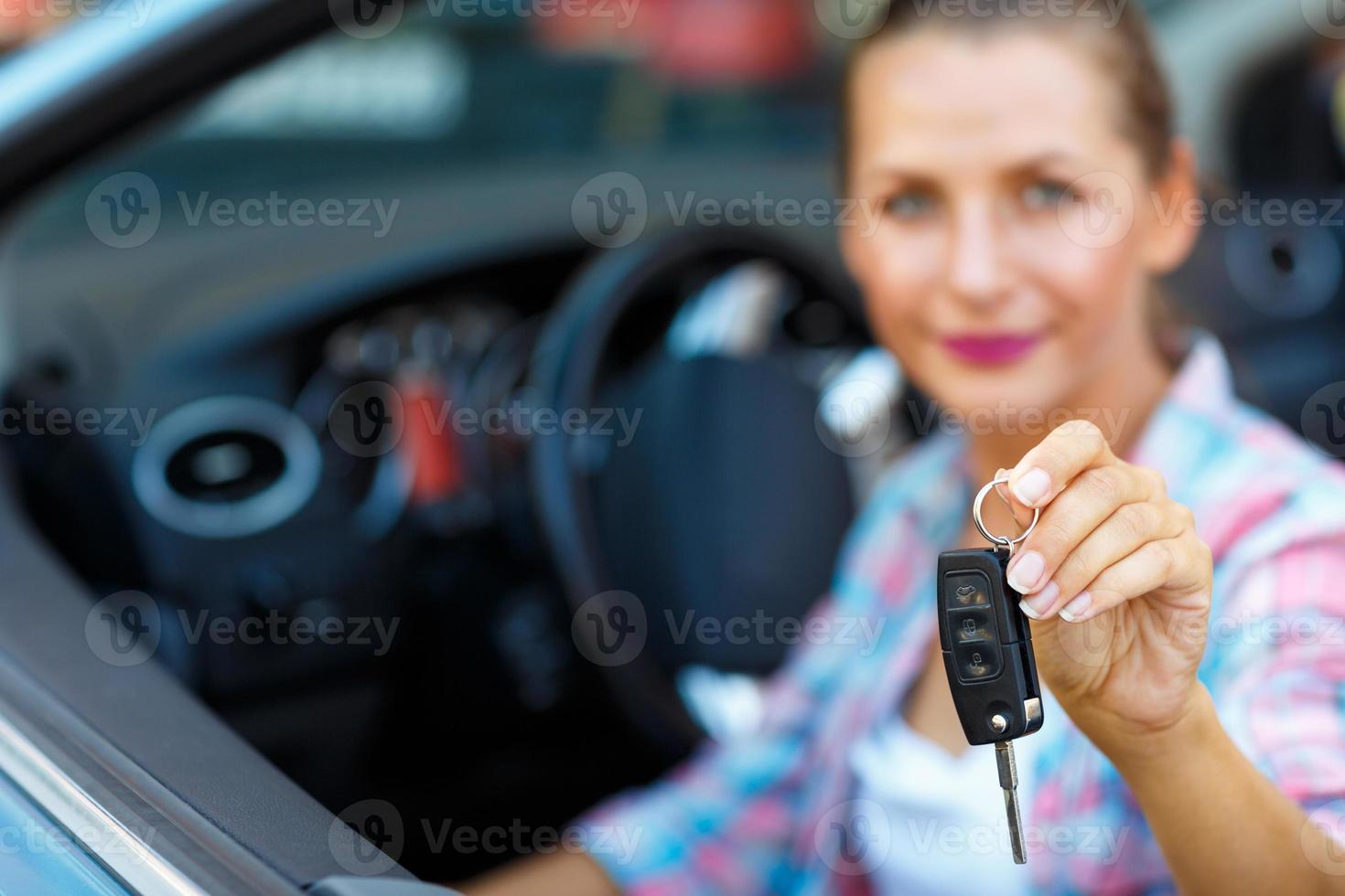 jovem bonita mulher sentado dentro uma conversível carro com a chaves dentro mão foto