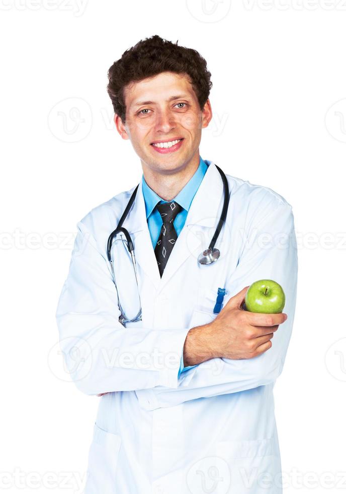 retrato do uma sorridente masculino médico segurando verde maçã em branco foto