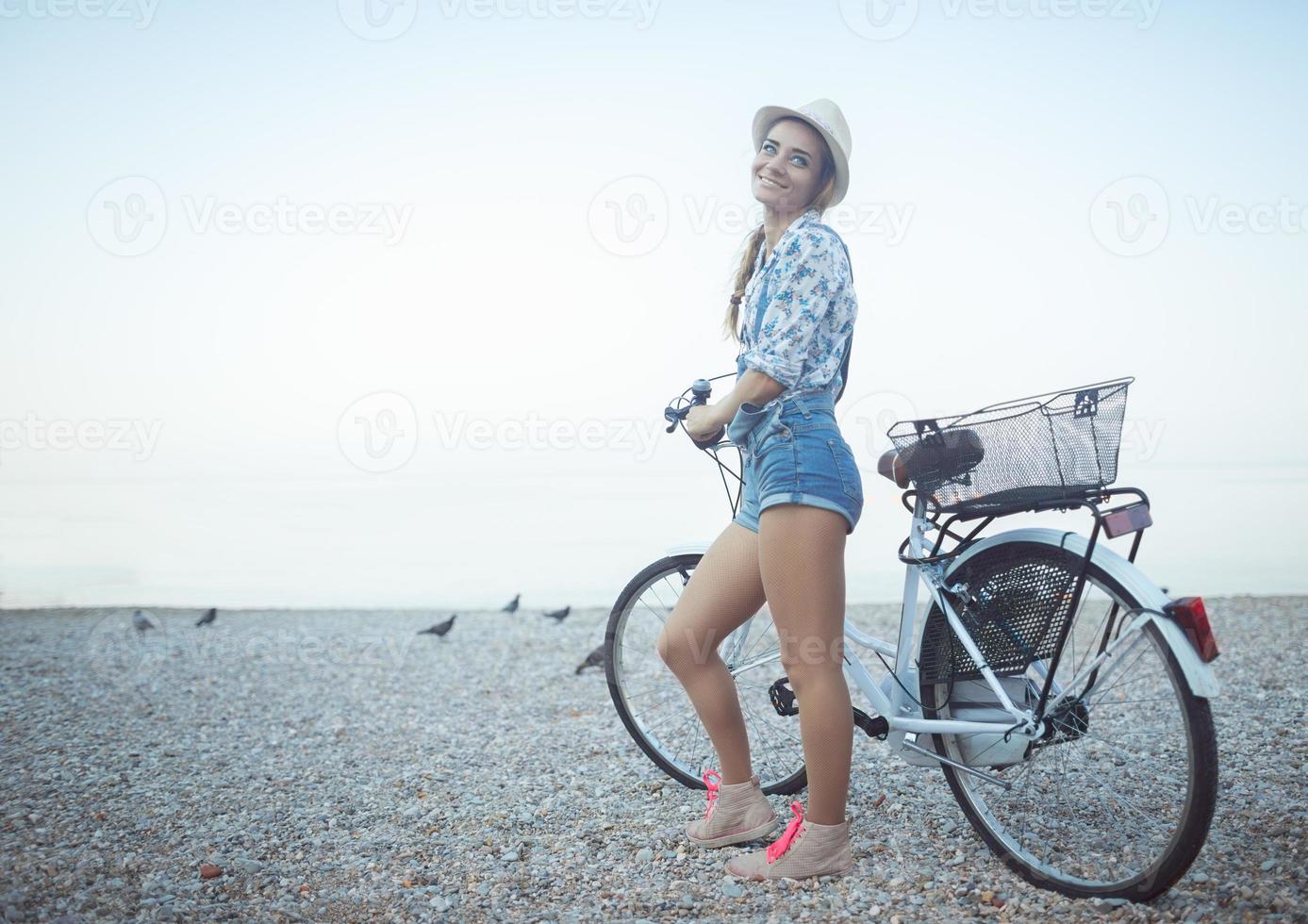 feliz mulher com bicicleta em a de praia foto