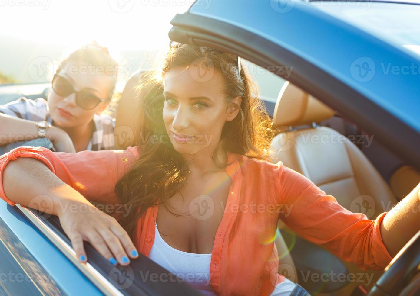 dois jovem meninas dirigindo uma cabriolet foto