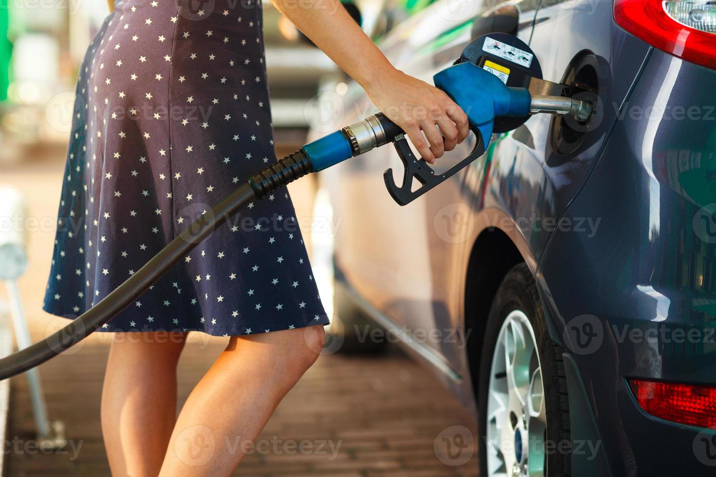 mulher preenche gasolina para dentro dela carro foto