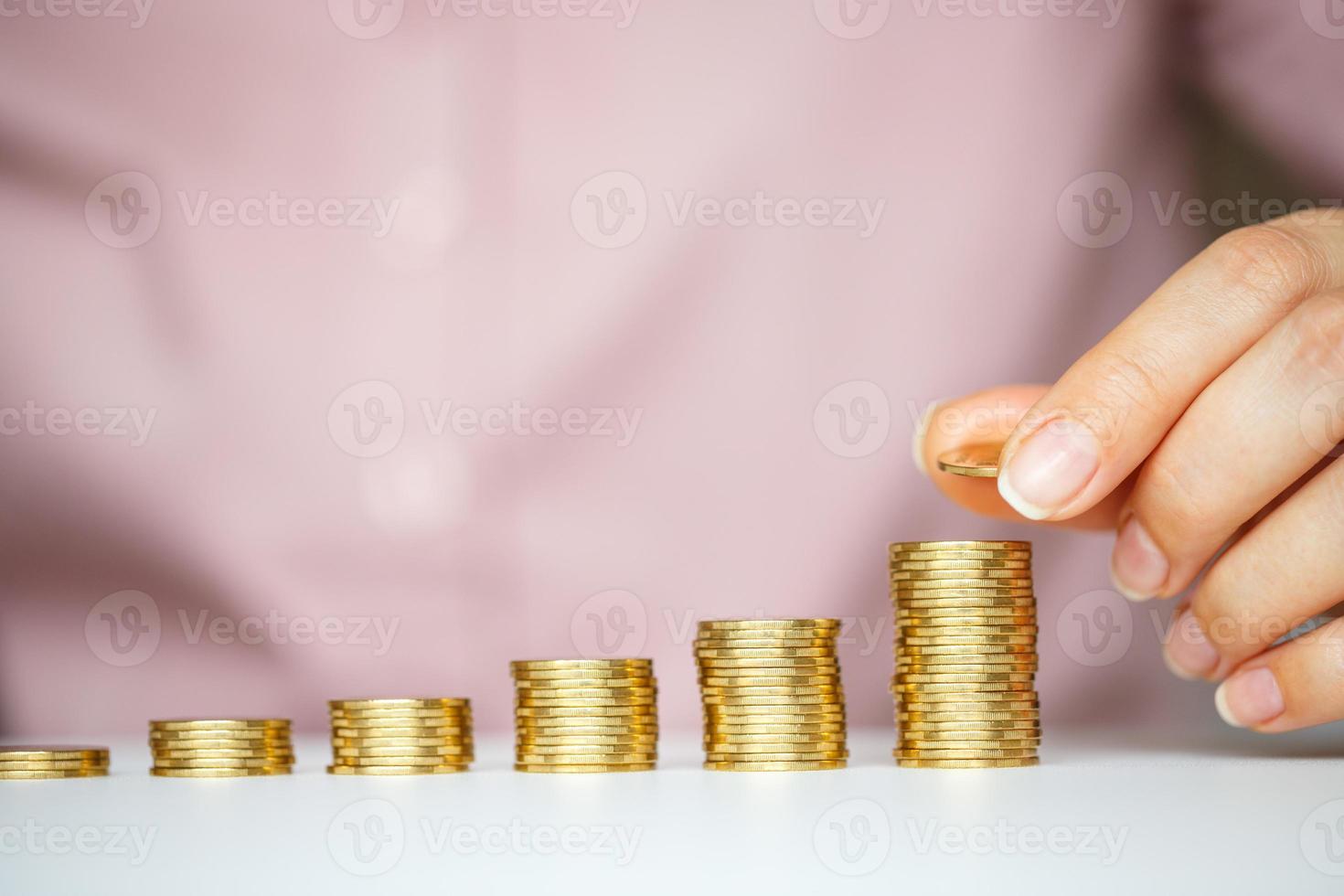 fêmea mão empilhamento ouro moedas para dentro aumentando colunas foto