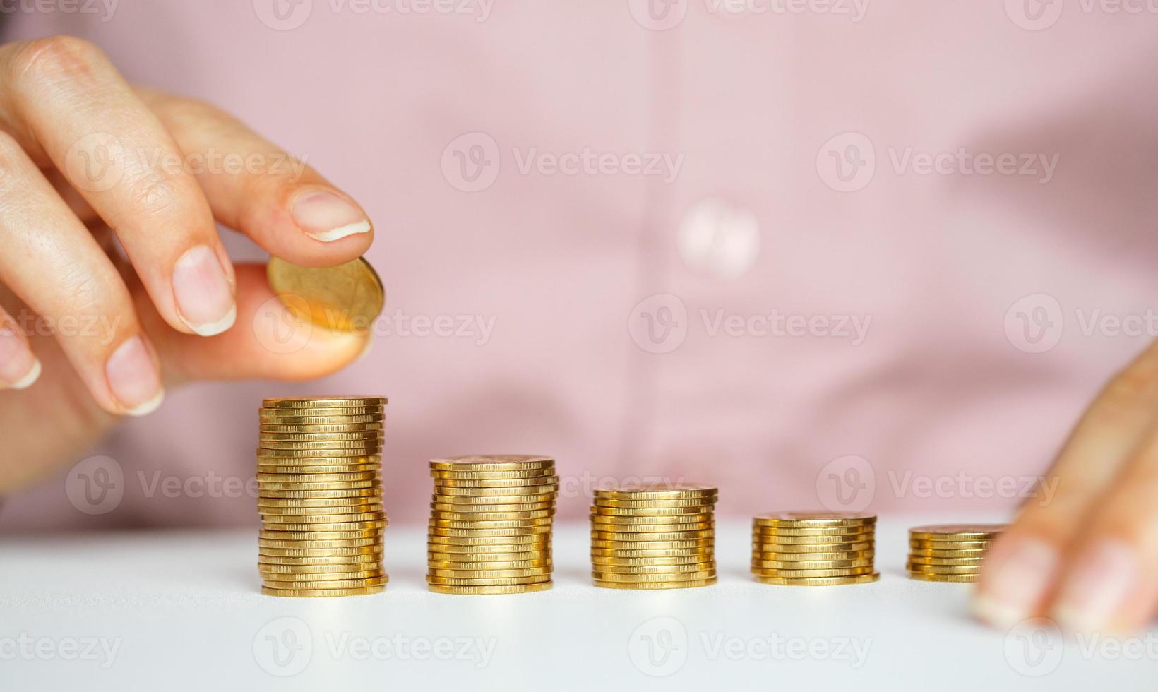 fêmea mão empilhamento ouro moedas para dentro aumentando colunas foto