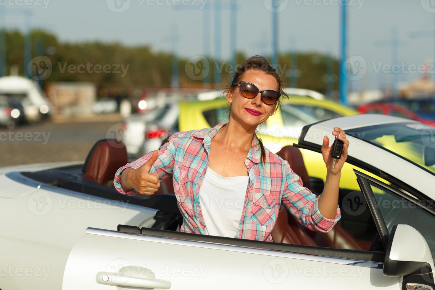 mulher em pé perto conversível com chaves dentro mão - conceito do comprando uma usava carro ou uma aluguel carro foto