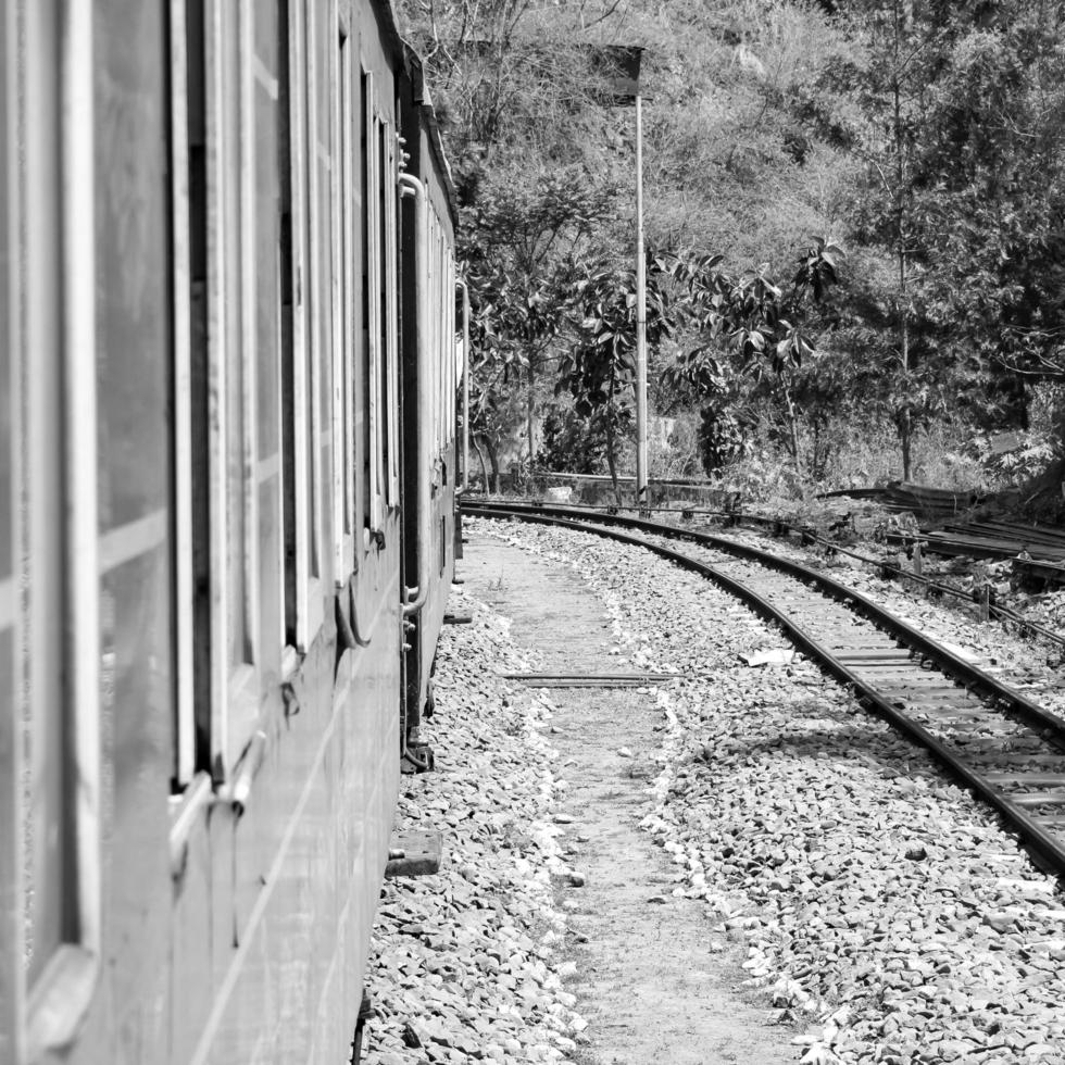 trem de brinquedo movendo-se nas encostas das montanhas, bela vista, uma montanha lateral, um vale lateral movendo-se na ferrovia para a colina, entre a floresta natural verde. trem de brinquedo de kalka para shimla na índia, trem indiano foto