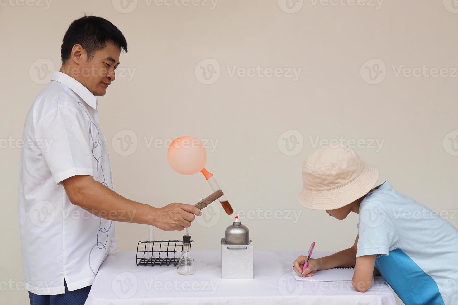 ásia homem professor é demonstrando Ciência experimentar sobre reação do balão em teste tubo é queimado a partir de lanterna para dele estudante. Ciência atividade. foto