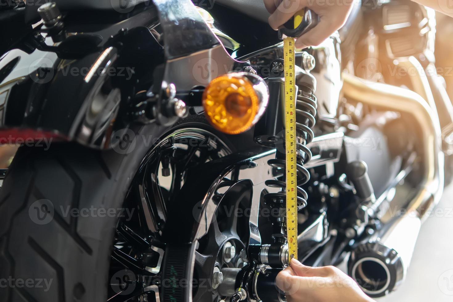 mecânico usando fita a medida conjunto acima suspensão flacidez compressão e rebote em motocicleta às garagem, reparar e manutenção motocicleta conceito .seletivo foco foto