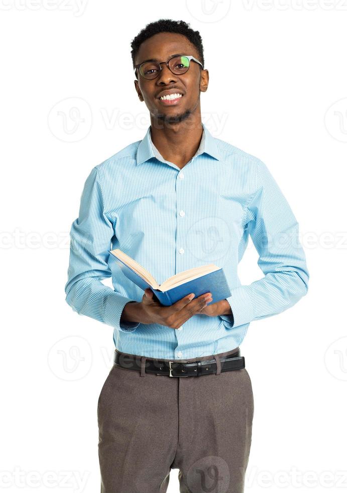 feliz africano americano Faculdade aluna com livro dentro dele mãos em pé em branco foto