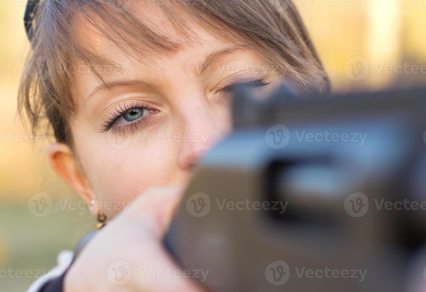 menina com uma arma de fogo para armadilha tiroteio e tiroteio óculos visando às uma alvo foto